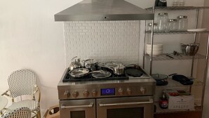 A kitchen with a stainless steel stove, oven, and a white brick backsplash. - 3-bedroom townhouse w/AC  Downtown walk to PPG Arena-Cultural Dist/Stadiums (Pittsburgh)