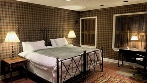 A bedroom with a four-poster bed, two bedside lamps, a desk with a chair, a window with shutters, and a patterned rug. - 3-bedroom townhouse w/AC  Downtown walk to PPG Arena-Cultural Dist/Stadiums (Pittsburgh)