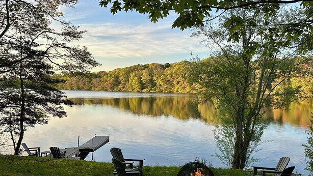 A lakeside outdoor seating area with Adirondack chairs, a fire pit, and a table. - Located directly on Pond, Swimming, Kayaking, Fishing, Beach Pass, A/C, Clean! (Barnstable)