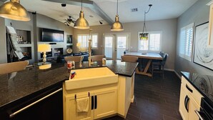 A spacious kitchen with a central island, pendant lighting, and a dining area with a table and chairs. - Sunstone Escape | Pool + Hot Tub | 3BR | 9 Min to Sports Complex | $510 Free Activities (Mesquite)