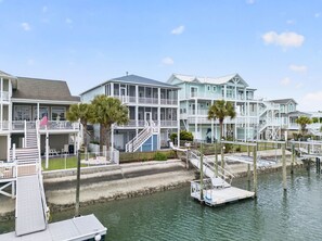 A waterfront hotel with multiple balconies, a dock, and a waterway. - Shrimply Fun- 5 bedroom and 4.5 bathrooms- a private dock provides access to the deep water canal. (Ocean Isle Beach)