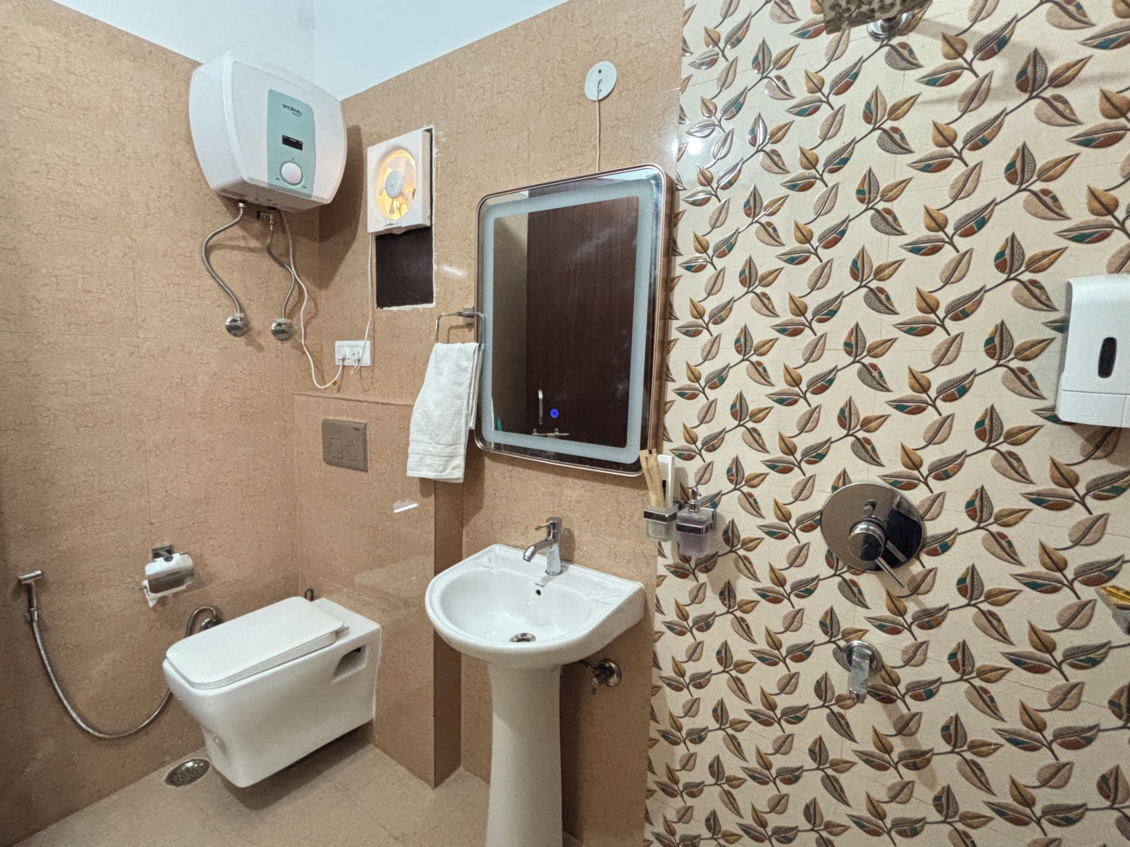 A bathroom with a toilet, sink, mirror, towel rack, and a shower.