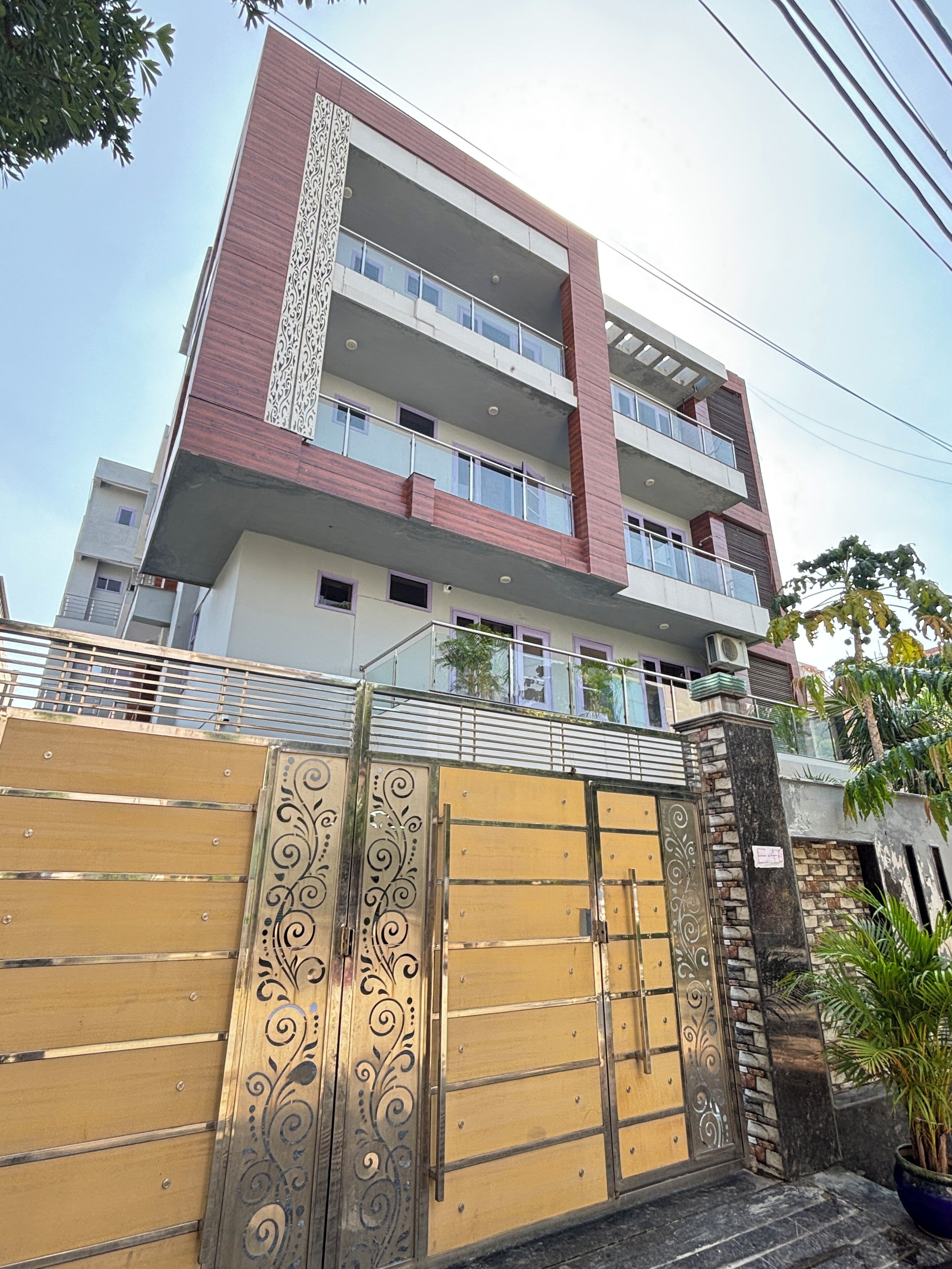Un edificio residencial de varios pisos con entrada protegida, balcones y un diseño arquitectónico moderno.