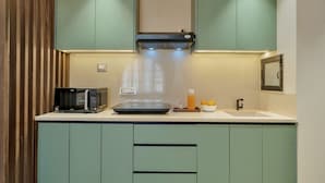 Eine kompakte Küche mit Mikrowelle, Toaster und kleinem Spülbecken.