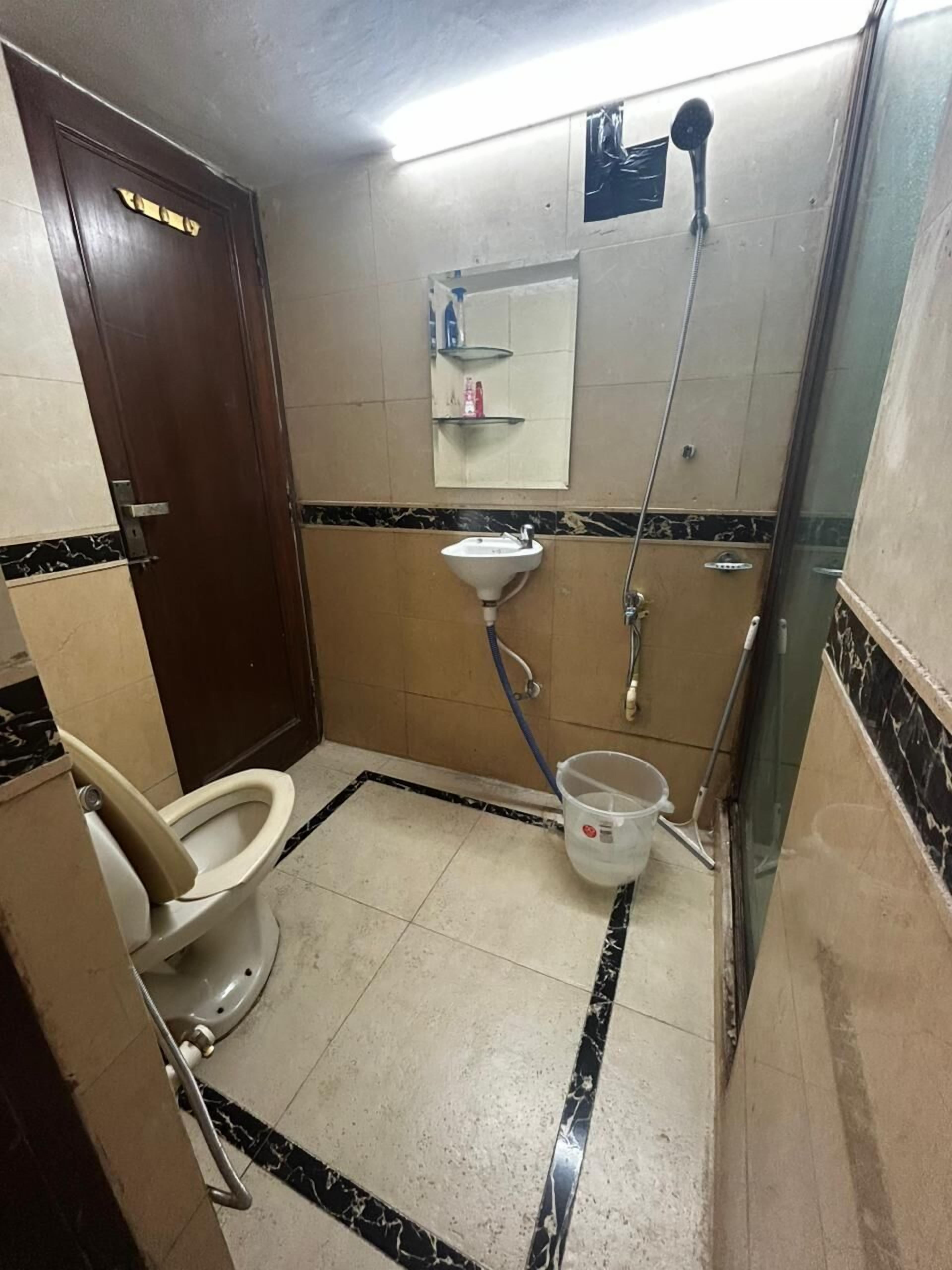 Une petite salle de bain avec des toilettes, un lavabo et une douche.
