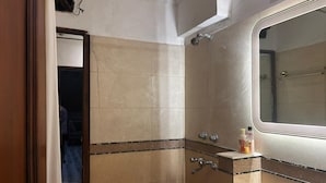 Een badkamer met een bad, een douche en een wastafel.