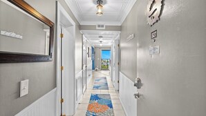 Un couloir d’hôtel avec un tapis à motifs, une vue sur l’extérieur et un panneau indiquant une zone non-fumeurs.