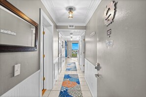 A hotel hallway with a patterned carpet, a view to the outside, and a sign indicating a non-smoking area. - 2 BR Ocean View Condo | Myrtle Beach Resort A0527 (Myrtle Beach)