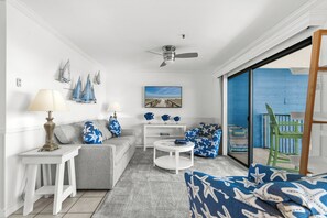 A living room with a sofa, a coffee table, a lamp, and a painting on the wall. - Ocean View 2 BR Condo: Myrtle Beach Resort B0546 (Myrtle Beach)