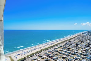 Une plage dotée d’un grand espace de stationnement pour les camping-cars et offrant une vue dégagée sur l’océan.