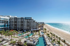 A hotel with a pool, beach, and ocean view.