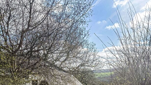 Eine Steintreppe führt zu einem weißen Gebäude mit Holzzaun und einem Gartenweg.