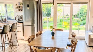 Una cocina moderna con refrigerador integrado, mesa de comedor de madera y sillas.