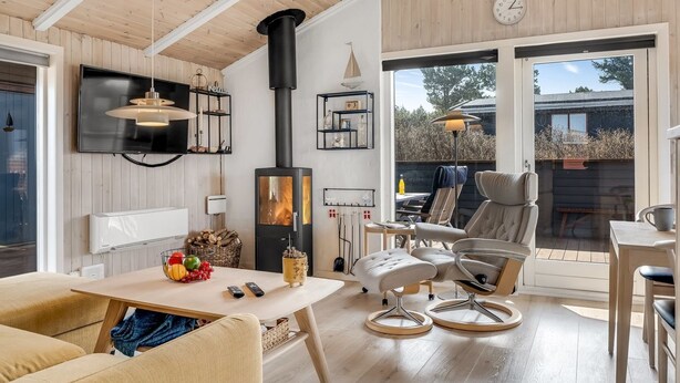 Ein gemütliches Wohnzimmer mit Kamin, Fernseher und Essbereich mit Stühlen und Tisch.