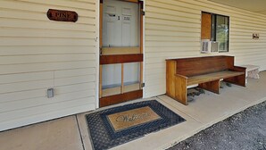 A Pine Lodge with a wooden bench outside, a welcome mat, and a door with a 'No Pets Allowed' sign. - Pine Lodge Cabin: Spacious + Mountain Views (Alto)