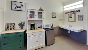A small kitchenette with a microwave, coffee maker, and a refrigerator. There is a green dresser with drawers and a small plant on top. - Wild Horses Cabinette: Studio + Mountain Views! (Alto)