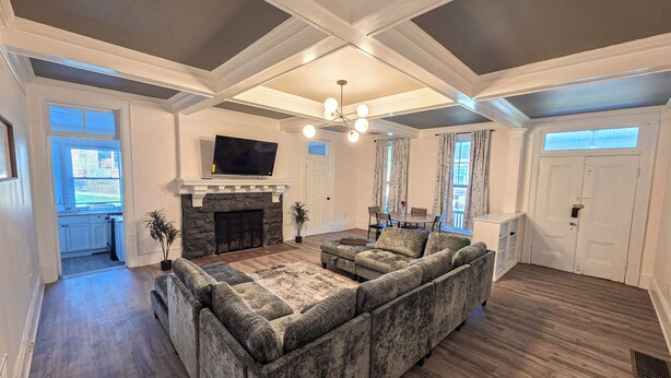 A living room with a fireplace, a large sectional sofa, and a flat-screen TV mounted above it. - Modern 1 BR Near York - Sleeps 3 - Renovated (Hallam)
