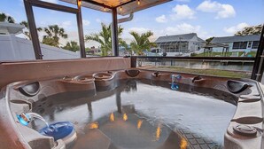 Una vasca idromassaggio con vista su una zona residenziale e un corso d'acqua.