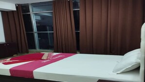 Une chambre à coucher avec un lit, des rideaux, une fenêtre et une armoire.