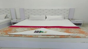Une chambre d’hôtel avec un lit, deux tables de chevet et une petite table d’appoint.