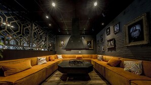 A modern lounge with a central coffee table, orange sofas, and framed pictures on the walls. - Active Dutch Getaway with Cycling Routes, Pool Access and Free Parking (Winterswijk)