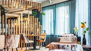 Ein modernes Interieur mit einer Holzwand, Tischen, Stühlen und einer Treppe.