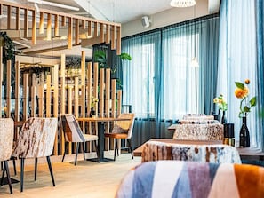 A modern interior with a wooden partition, tables, chairs, and a staircase. - 2 units in Prime location near city center, Seaside Pier and local sites (Den Haag)