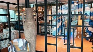 Une pièce dotée d’une grande fenêtre, d’un fauteuil et d’une structure décorative en pierre.