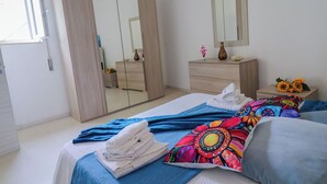Une chambre à coucher comprenant un lit, une commode, un miroir et une armoire.