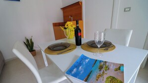 Une table à manger avec un magazine, une bouteille de vin et un verre.