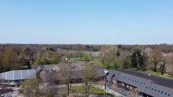Ein modernes Gebäude mit flachem Dach, großen Fenstern und einem Parkplatz.