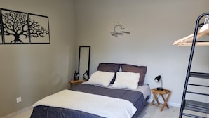 A bedroom with a bed, two bedside tables, a mirror, a wall-mounted shelf, and a ladder. - Modern, air-conditioned house with private pool sleeps 6 (Entraigues-sur-la-Sorgue)