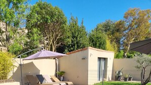 A swimming pool with lounge chairs, a small building, and surrounding greenery. - Modern, air-conditioned house with private pool sleeps 6 (Entraigues-sur-la-Sorgue)