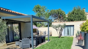 A patio area with outdoor furniture, a pergola, and a well-maintained lawn. - Modern, air-conditioned house with private pool sleeps 6 (Entraigues-sur-la-Sorgue)