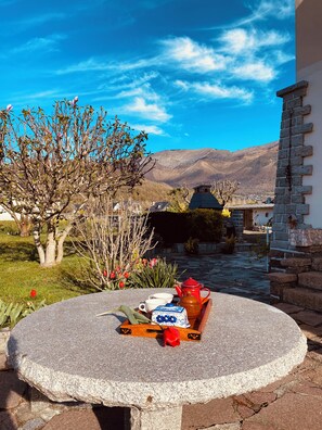 A stone table with a tray of tea set and a view of a mountainous landscape. - 360° View of the Pyrenees: Nature, Cycling, and Comfort (Argelès-Gazost)