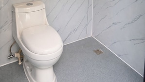 Un bagno con il water, una doccia e un punto luce a parete.