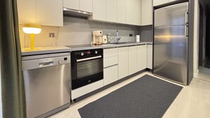 Una cocina moderna con electrodomésticos de acero inoxidable, un lavavajillas Bosch y una cafetera.