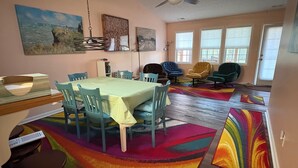 A dining area with a table, chairs, and a ceiling fan.