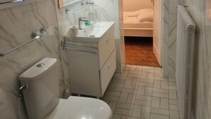 Et badeværelse med toilet, håndvask og spejl.