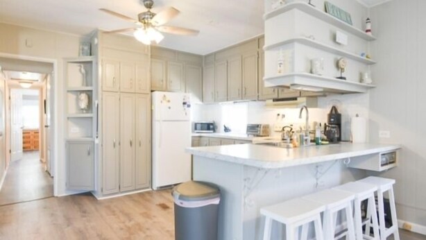 A modern kitchen with a central island, white bar stools, and a ceiling fan. - 3 BR 2 BA located in the Montego Bay Community, 2 Pools Tennis. Pets welcome (Ocean City)