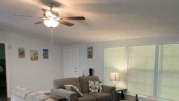 A living room with a sofa, a coffee table, a ceiling fan, and a lamp. - Charming 3-bedroom 2 Bath farmhouse on 7.4 Acres (Trenton)