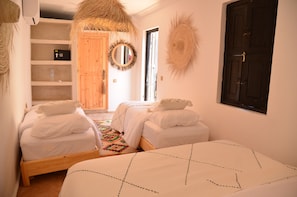 Un dormitorio con dos camas, un armario de madera, un espejo y una puerta.