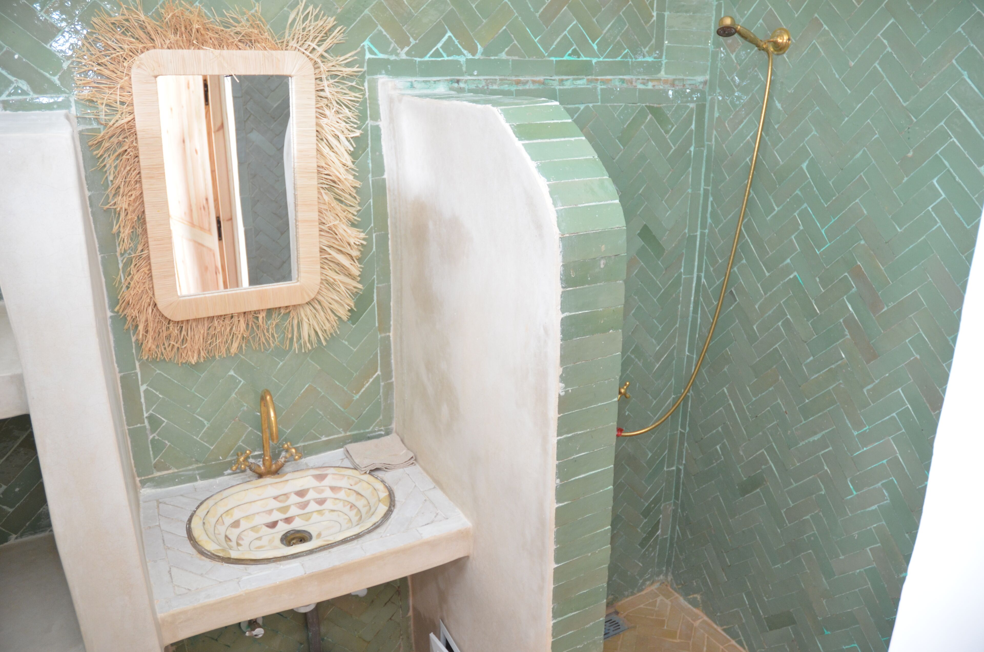 A bathroom with a mirror, sink, and shower.