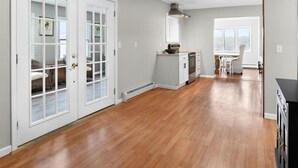 A spacious kitchen with wooden flooring, white cabinetry, and a built-in oven. - Country Fields, Wine Country, Pool and More (Auburn)