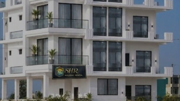 Un edificio a più piani con balconi e un cartello con la scritta 'SHR'.
