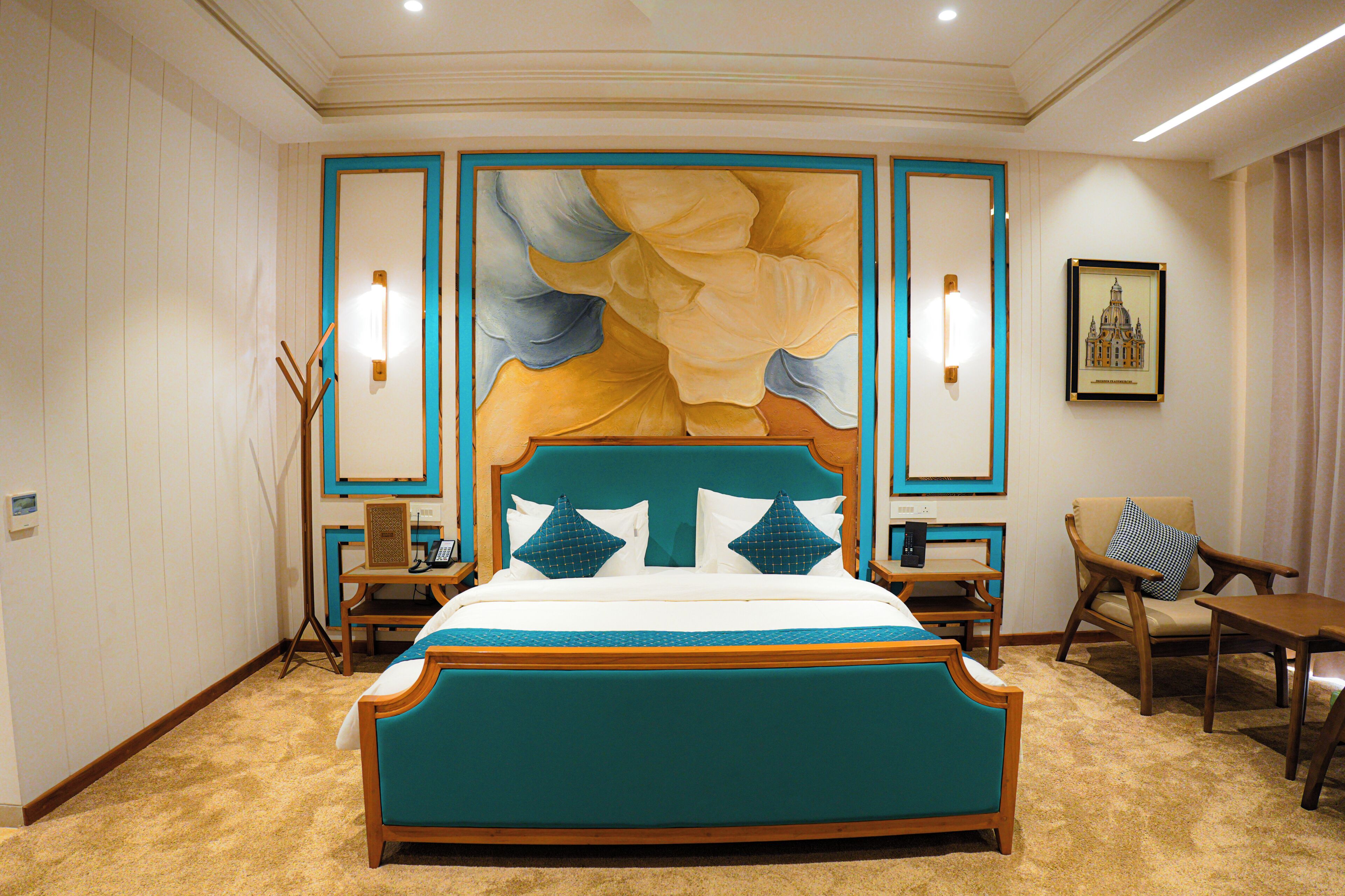 A bedroom with a large bed, bedside tables, a chair, and a wall-mounted lamp.