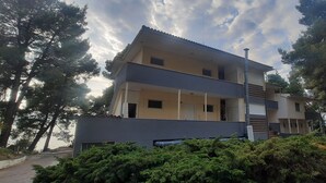 A multi-story residential building with balconies, surrounded by trees. - Dryades Hotel (Kassandra)