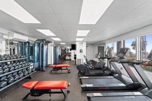 A gym with treadmills, weight machines, and dumbbells. - Luxury 3BR Beachfront Condo Sleeps 8 Gulf Views (Panama City Beach)