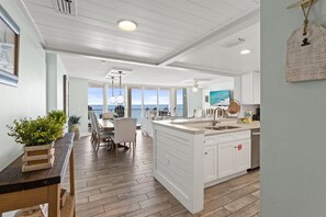 A spacious kitchen with a large island, white cabinetry, and a view to the outside. - Luxury 3BR Beachfront Condo Sleeps 8 Gulf Views (Panama City Beach)