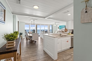 A spacious kitchen with a large island, white cabinetry, and a view to the outside. - Luxury 3BR Beachfront Condo Sleeps 8 Gulf Views (Panama City Beach)